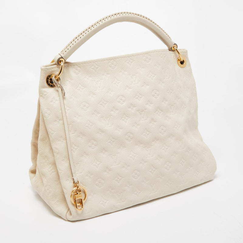 Experience the enchanting beauty of the Louis Vuitton Artsy MM Neige Monogram  Empreinte Leather Bag as you gracefully drape it over your…